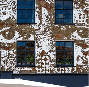 The façade of Gold on Portobello Road, covered by Vhils' Eye Contact mural
