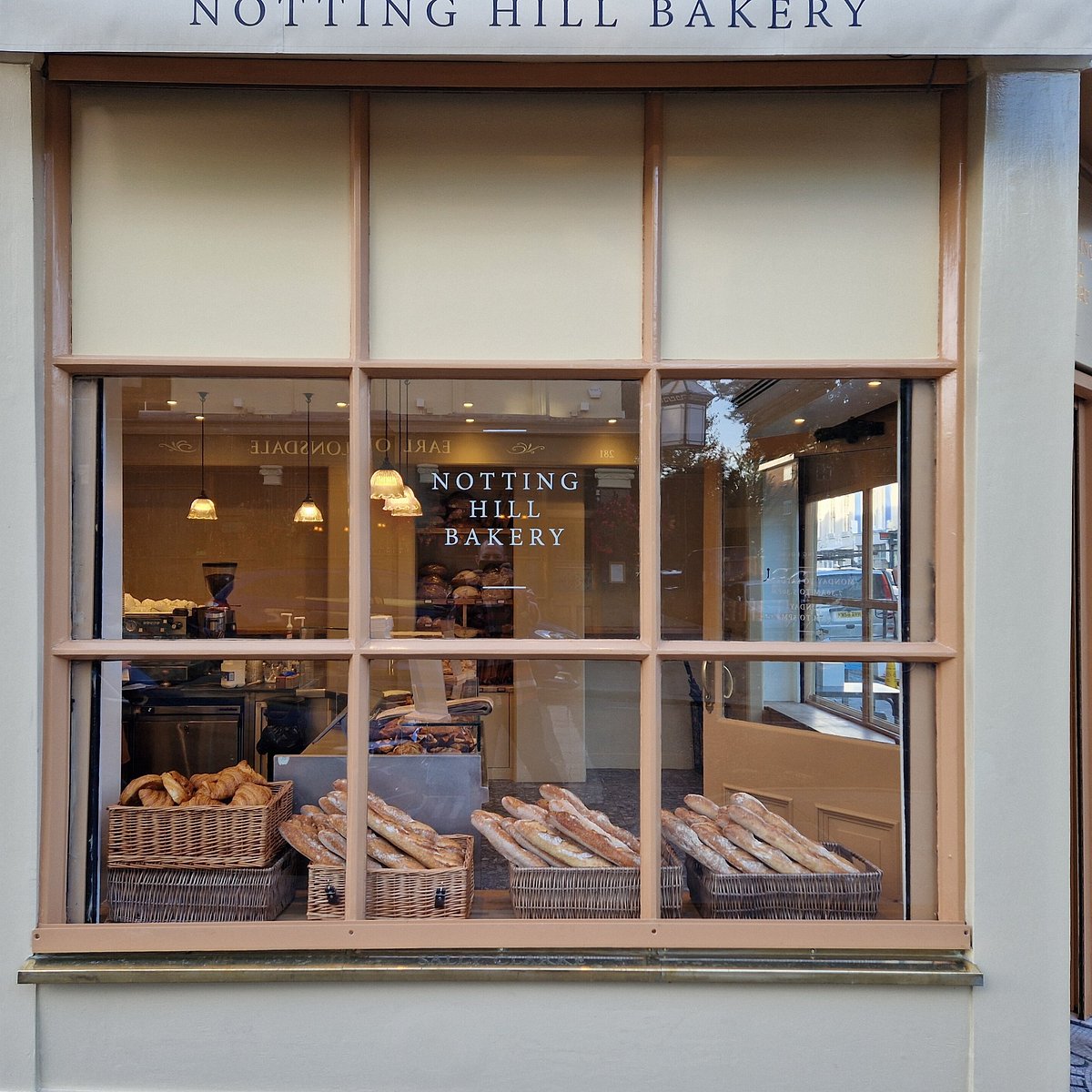 Baskets of baguettes and croissants in the window of Notting Hill Bakery