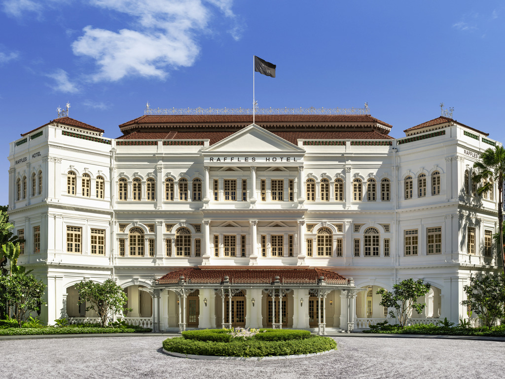 The white colonial façade of Raffles Hotel Singapore, with its central entrance and red-tiled roof