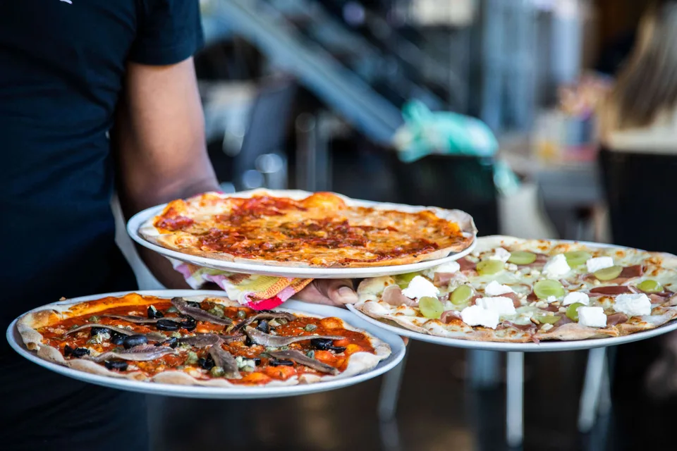 Thin-crust pizzas carried out to the tables at Pizzeria Casavostra, Almancil