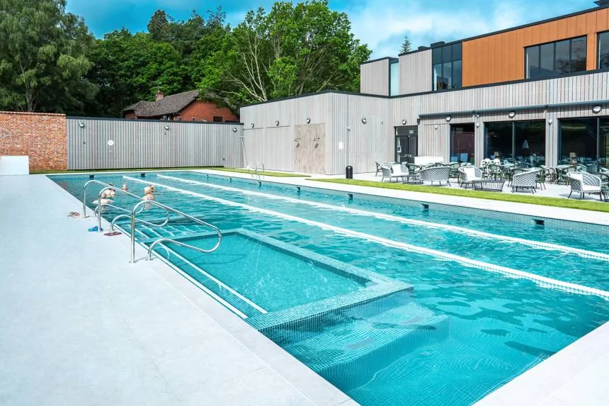 The outdoor lap pool at Foxhills, lanes marked out beside the timber-clad Pavilion and its terrace tables