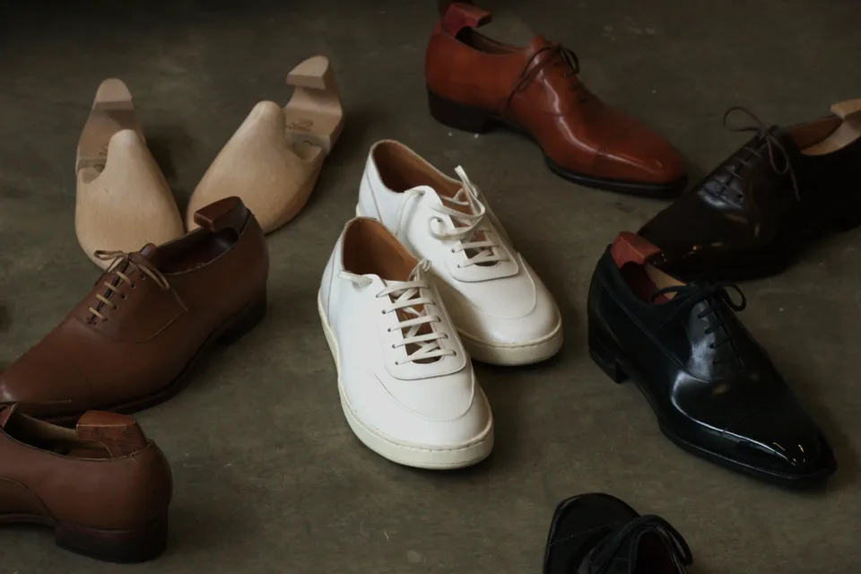 Fumu bespoke shoes and wooden lasts arranged on the workshop floor in Singapore