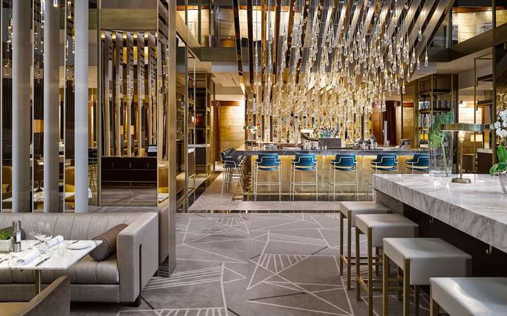 The contemporary bar at Torre Melina, with mirrored columns and a canopy of suspended glass lights