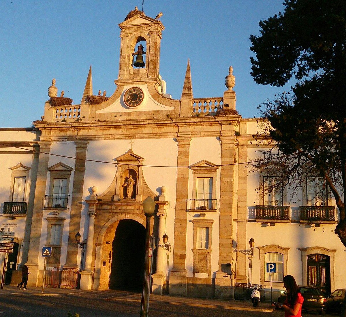 The Arco da Vila in Faro in evening sun, its bell tower topped by storks' nests
