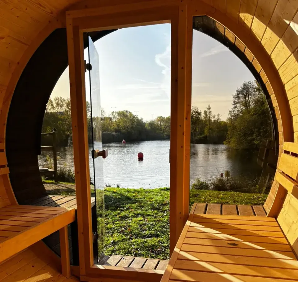 View from inside Other Fold's barrel sauna towards the lake at Boston Manor Park