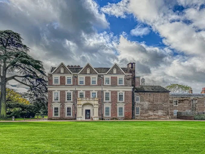 The Jacobean façade of Boston Manor House beneath a broad cedar tree