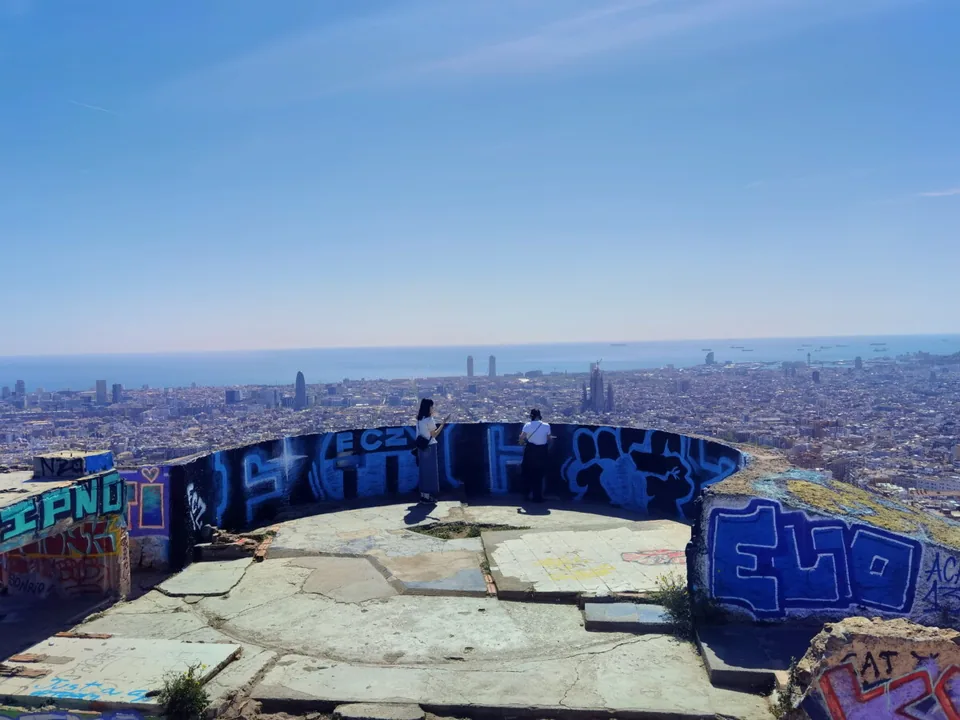 The concrete remains of the Turó de la Rovira anti-aircraft battery above Barcelona, with graffiti walls and the city below