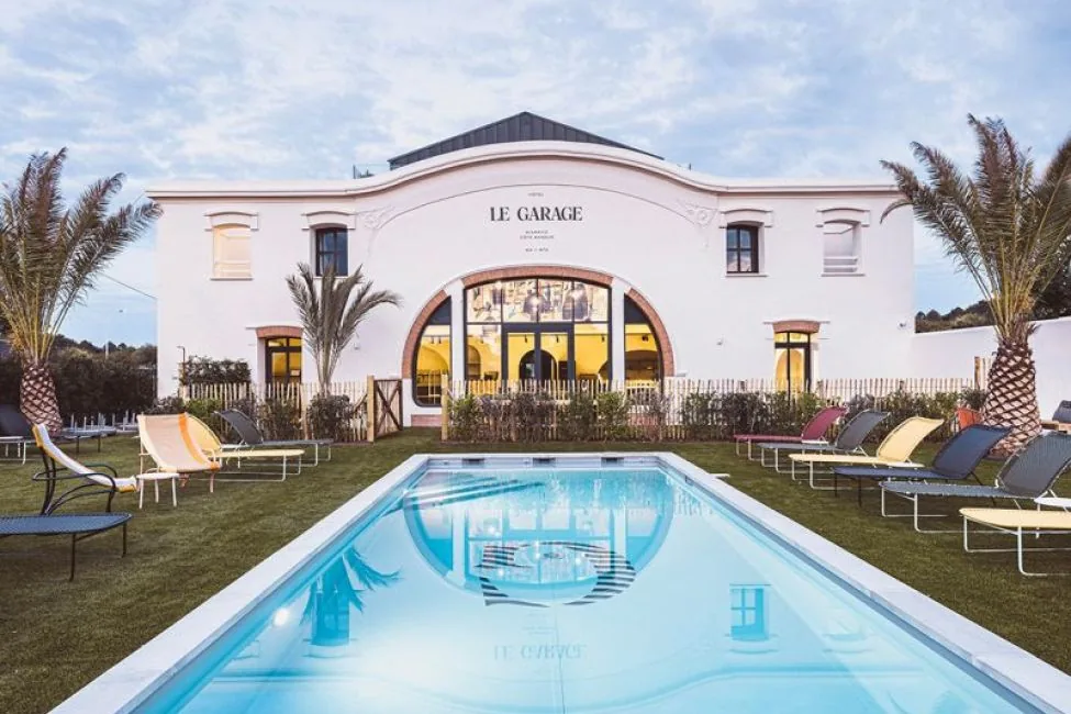 Hôtel Le Garage Biarritz — the arched white facade and outdoor pool at dusk