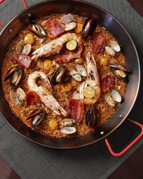 Hokkien Mee Fideuà served in a pan with prawns, clams and mussels