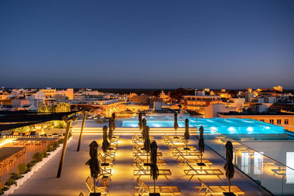 The rooftop at 3HB Faro at dusk above the city's rooftops