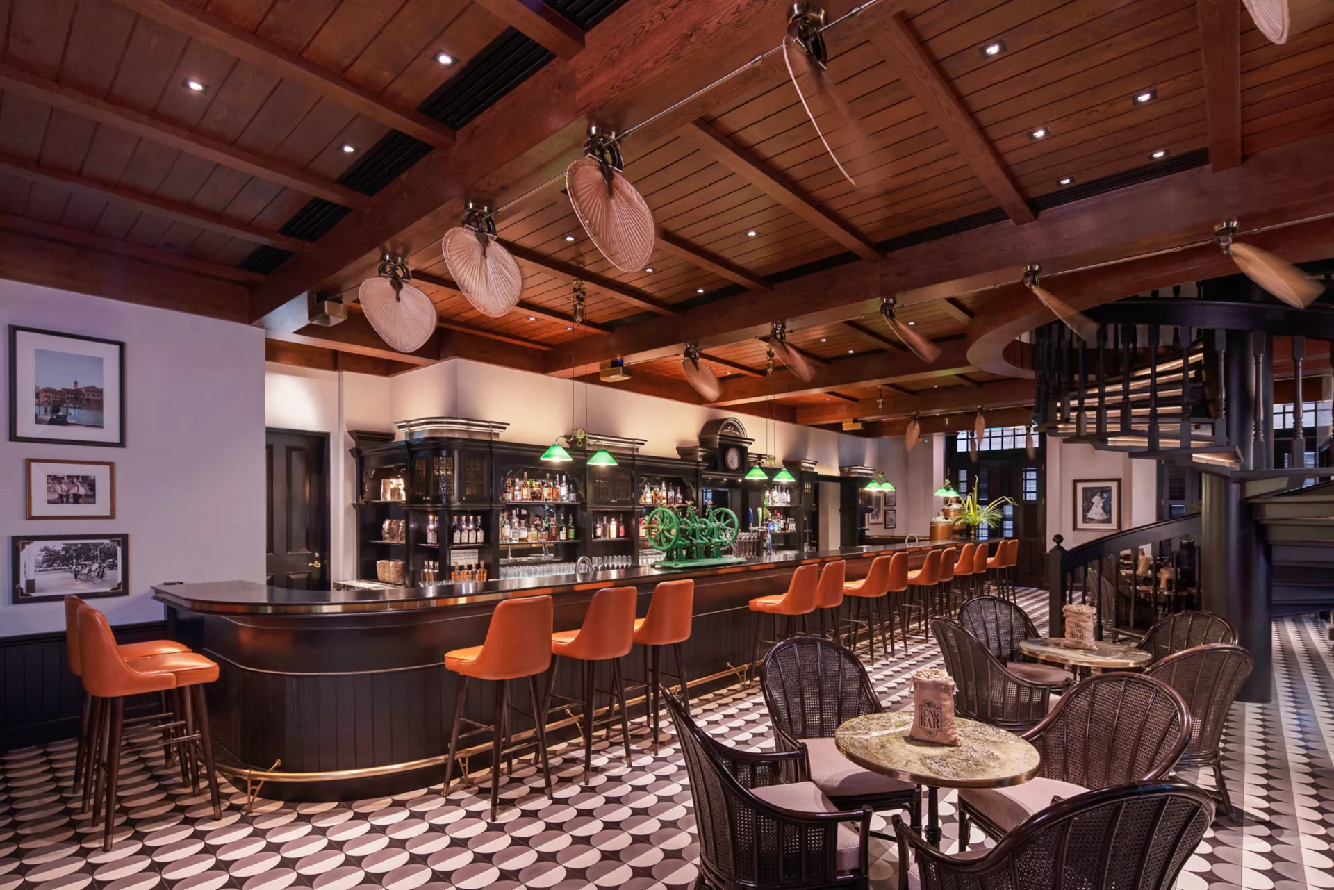 The Long Bar at Raffles Singapore with ceiling fans and patterned floor tiles