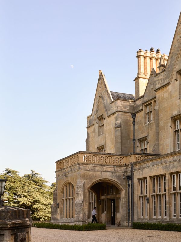 The arched stone entrance porch and mullioned windows of Dumbleton Hall