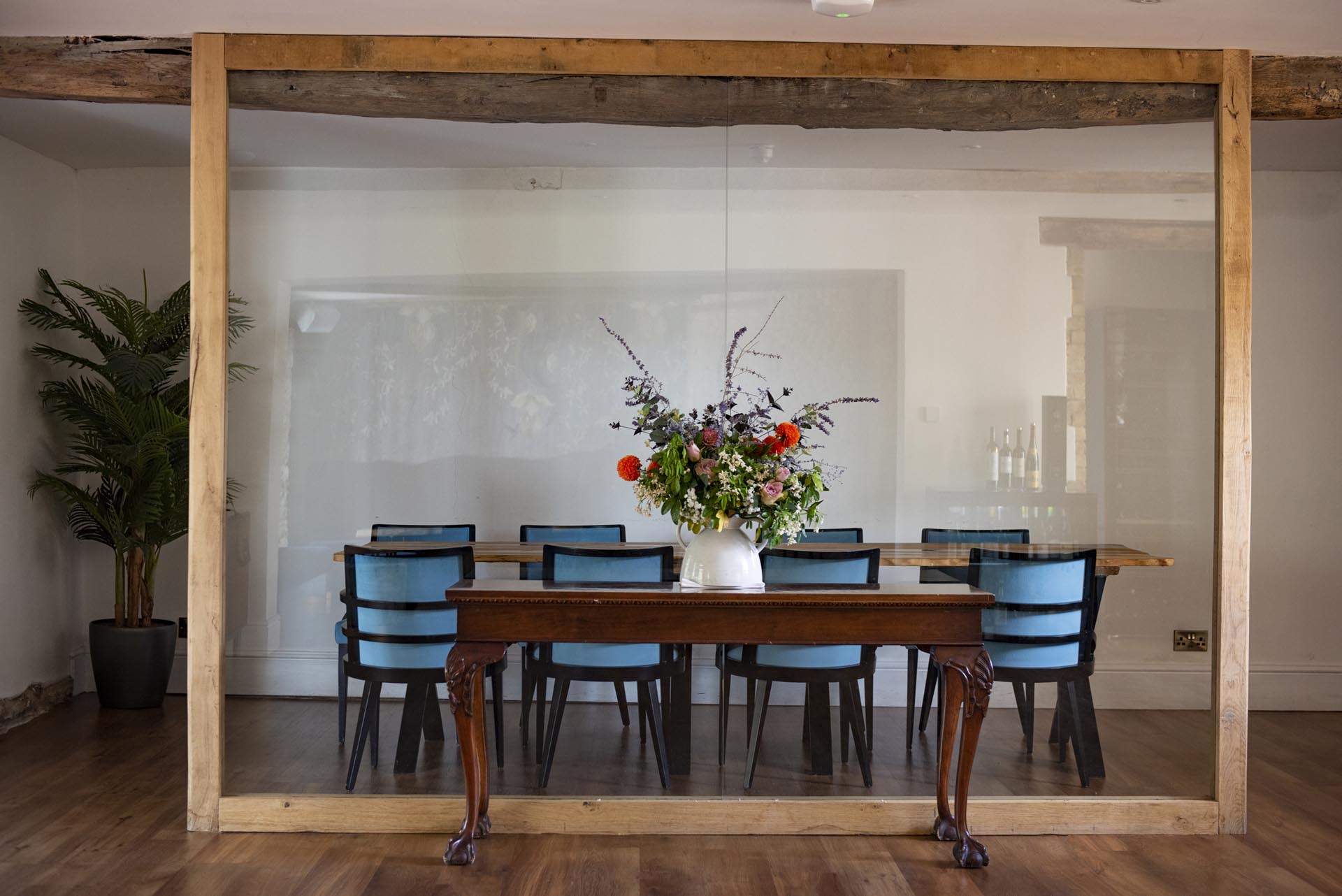 A flower-filled private dining room at the Haycock Manor Hotel framed by old timber beams