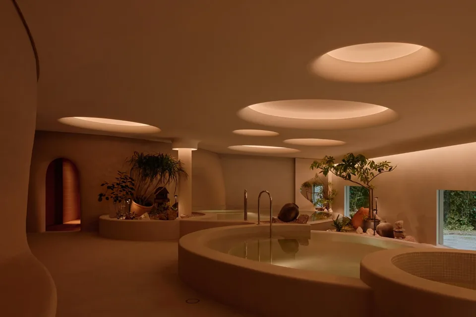 Warm communal bathing pools beneath circular skylights at Nowhere Baths in Dempsey