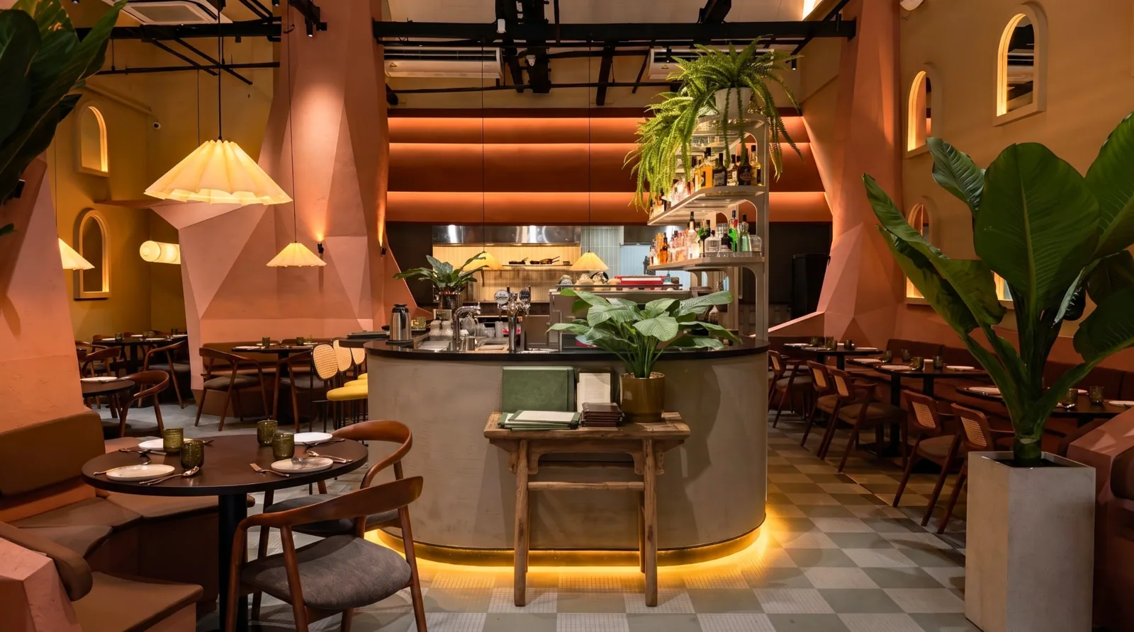 Casa Mori dining room with terracotta walls, greenery and a curved central bar