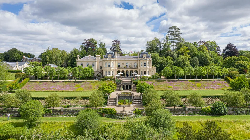 Beaverbrook — the mansion seen across its terraced gardens, lawns and clipped trees in the Surrey Hills