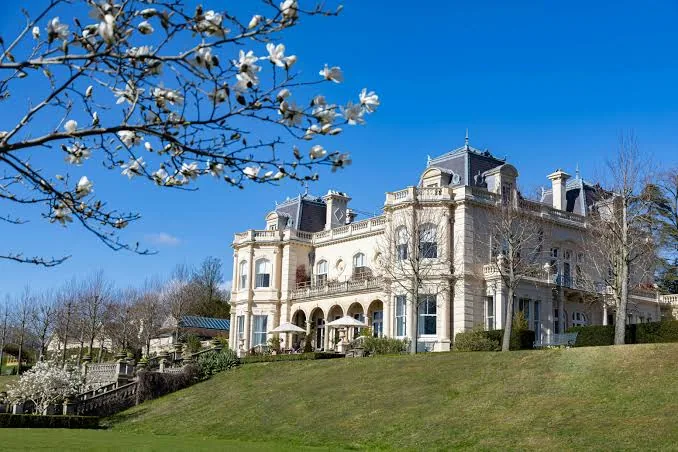 Beaverbrook — the late-Victorian mansion on its Surrey Hills estate, seen under magnolia blossom in spring