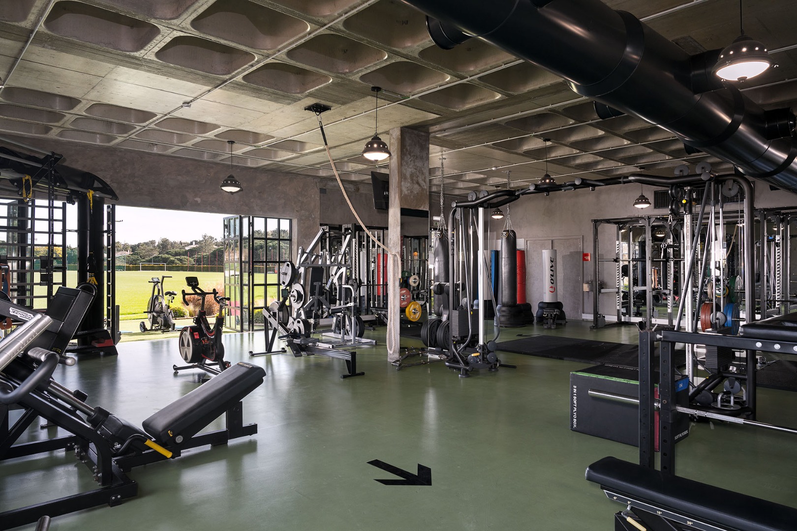 The pitch-side gym at The Campus, its doors open onto the training pitch
