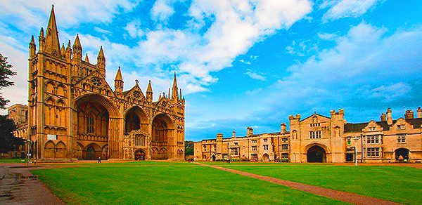 Peterborough Cathedral's three-arched West Front beside the green and historic precinct buildings