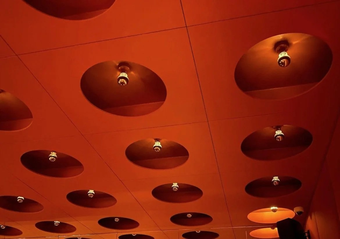 The orange ceiling at Naked & Famous, set with round light wells and bare bulbs