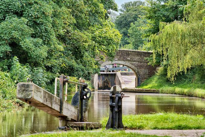 A canal lock and bridge among trees at Hanwell