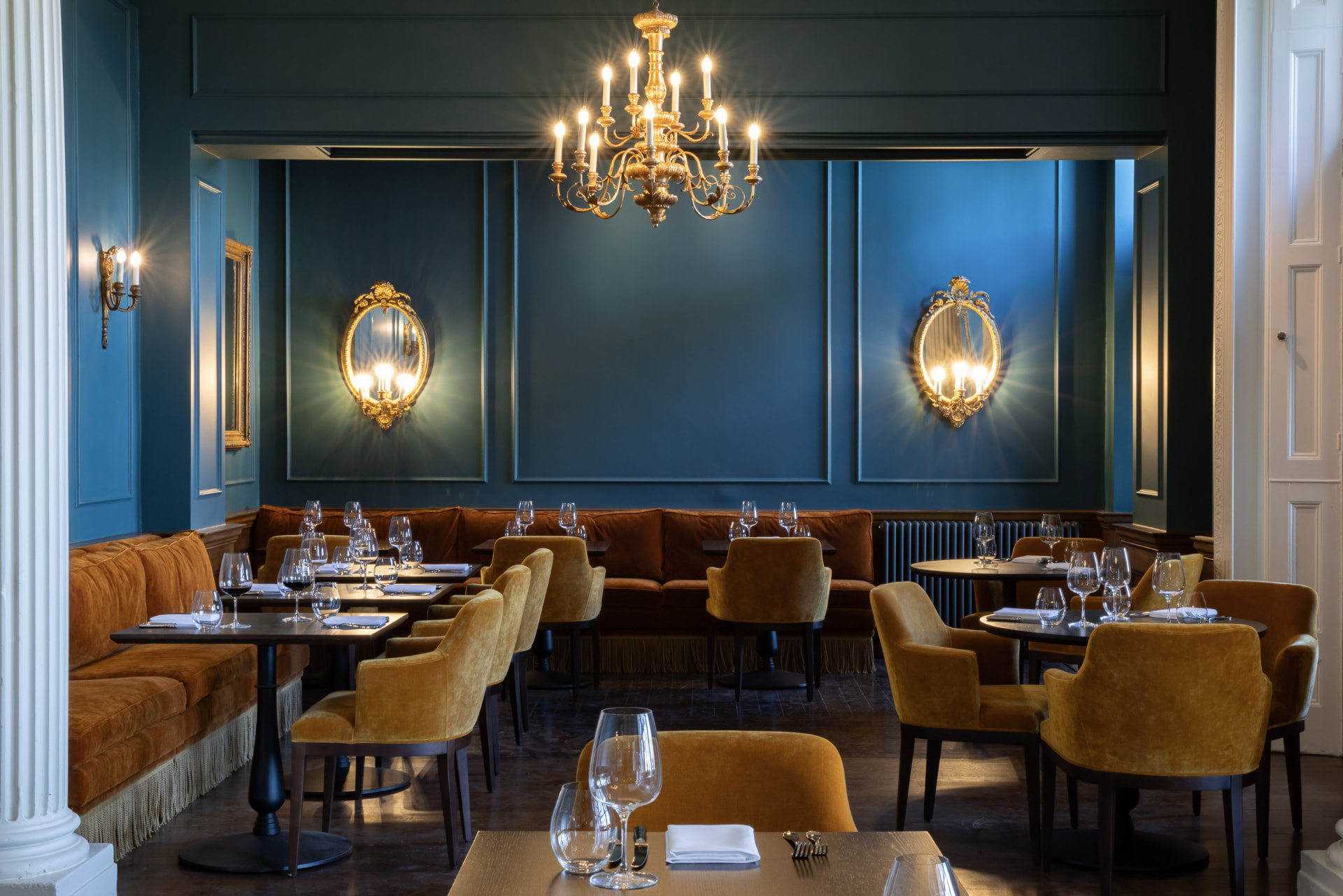 Cedar 1905 at Dumbleton Hall — deep blue panelled walls, gilt-framed mirrors and ochre velvet seating