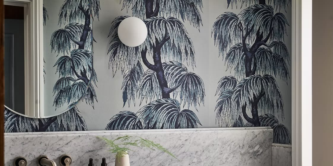 Willow-patterned wallpaper, a globe light and a marble basin in a bathroom at The Lost Poet, Notting Hill