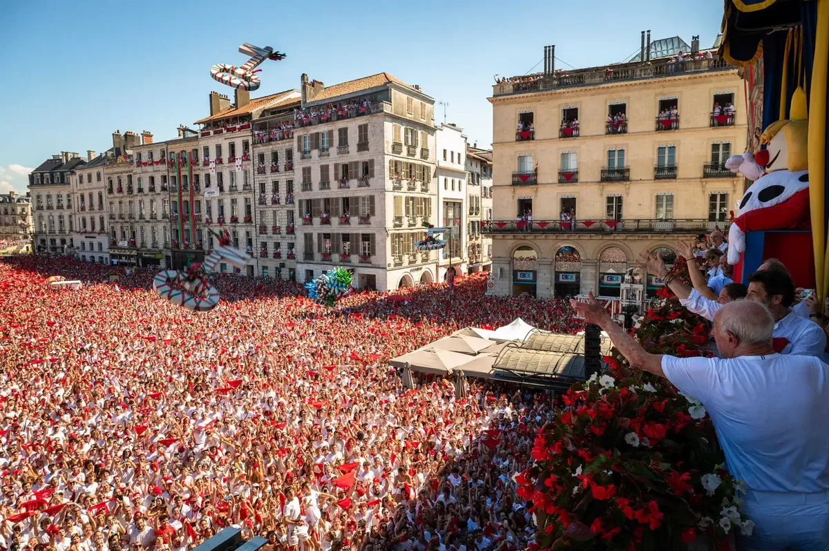 The view from a Bayonne balcony over a red-and-white crowd, with King Léon at the edge of the frame