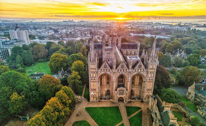 Peterborough Cathedral seen from above at sunset, with its three-arched West Front facing the precinct